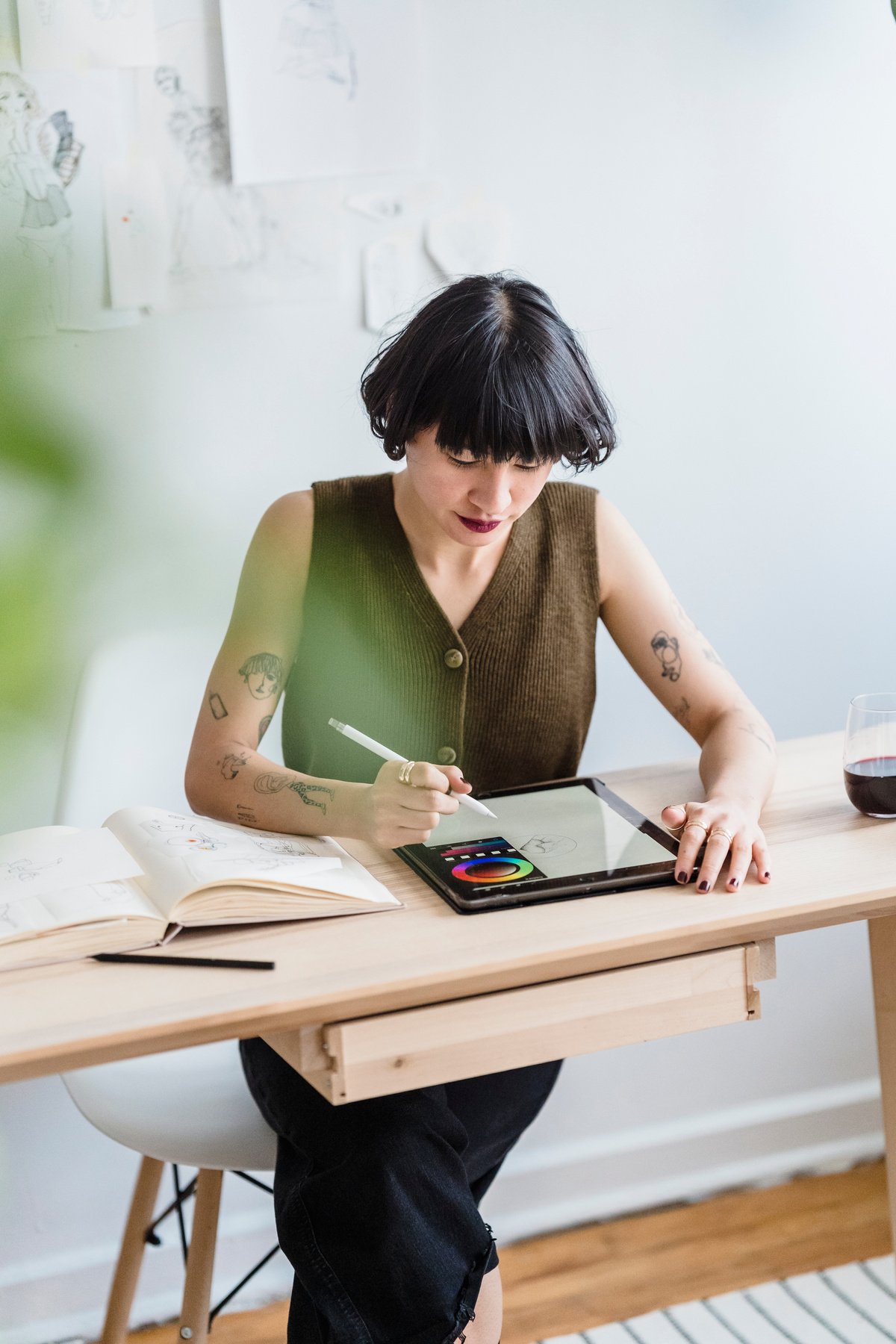 Asian woman drawing on graphics tablet while sitting in studio